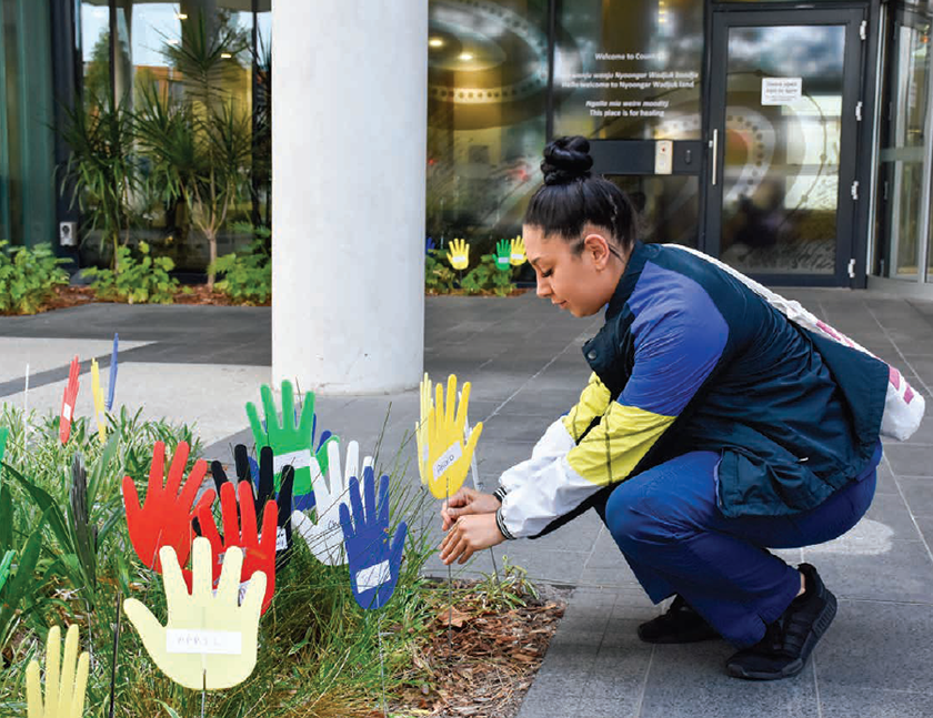 Image of caregiver kneeling down planting a hand for the RAP