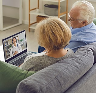 Image of couple sitting on couch having a telehealth session