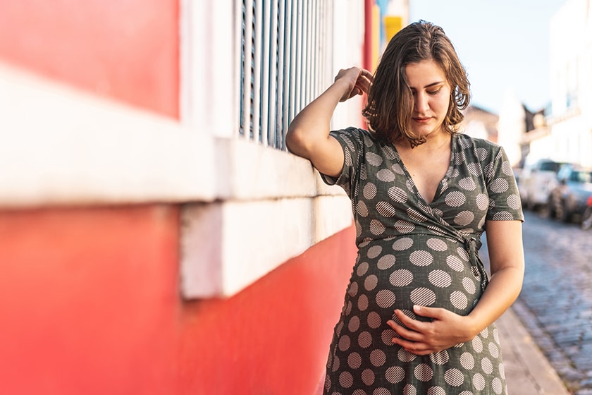 A woman cradles her pregnant belly