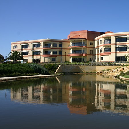 Exterior of the Murdoch Hospital main ward block with lake in the foreground