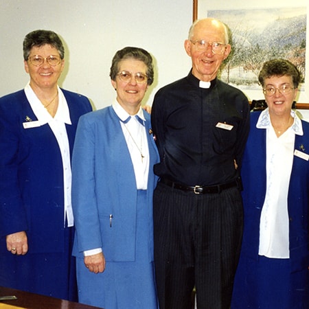 Five members of the St John of God Murdoch Hospital Pastoral Services team stand beside each other and smile at camera